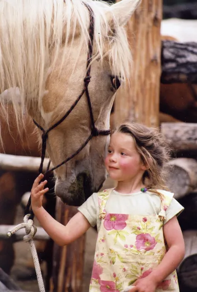 Children's program includes horse care: girl with horse