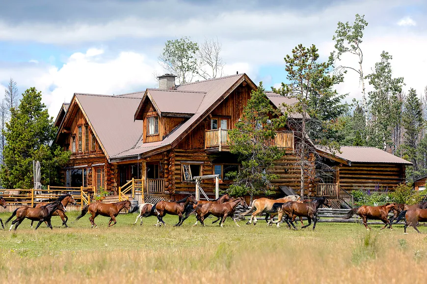 Horses gallop past the lodge at this award winning luxury dude ranch and wilderness resort